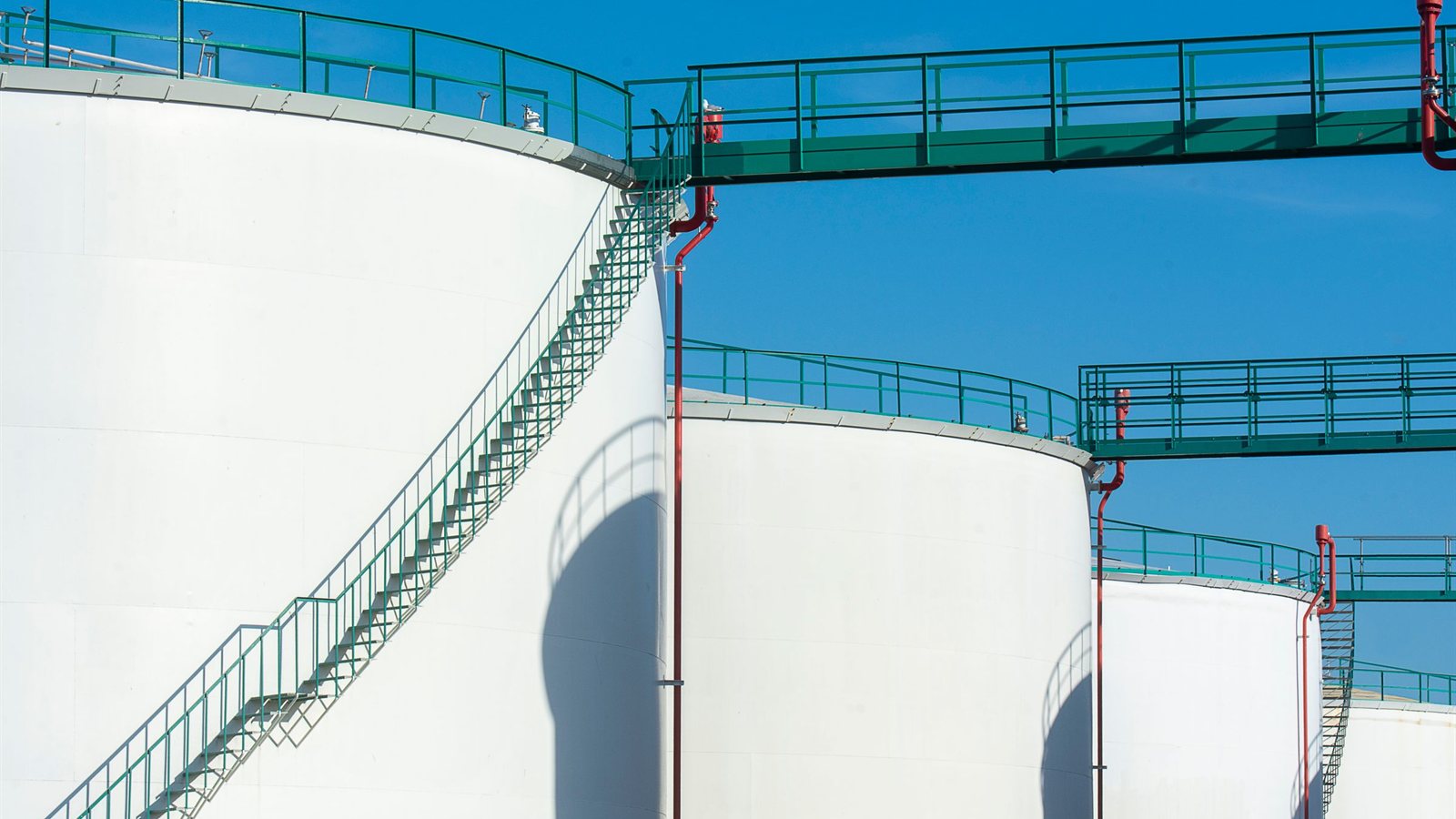 Industrial fuel storage tanks connected by walkways, representing the fuel forecasting problem the dissertation addressed