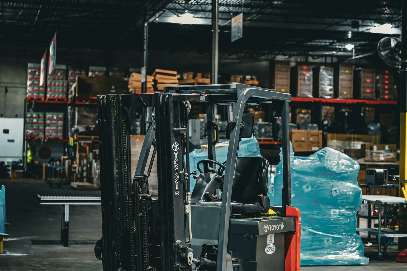 A forklift parked in a warehouse aisle among shelved pallets and crates, the kind of dispatch floor where a picking error can send the wrong item out the door