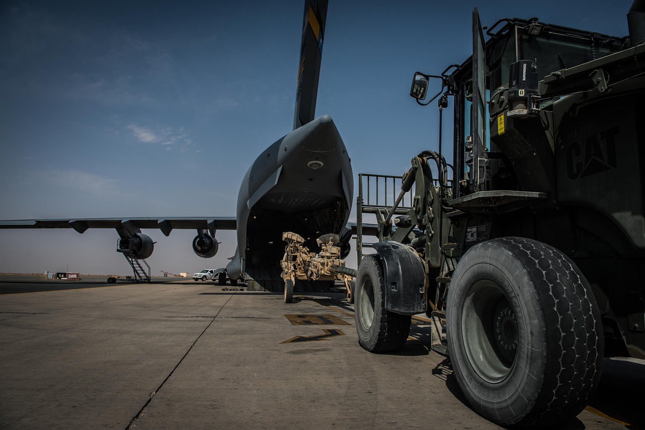 Military cargo aircraft being loaded on the tarmac